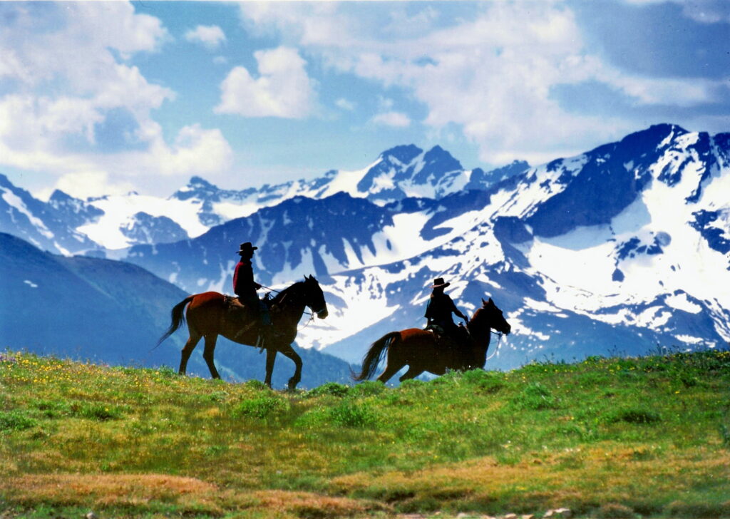 2 paarden met ruiter in de bergen in Canada